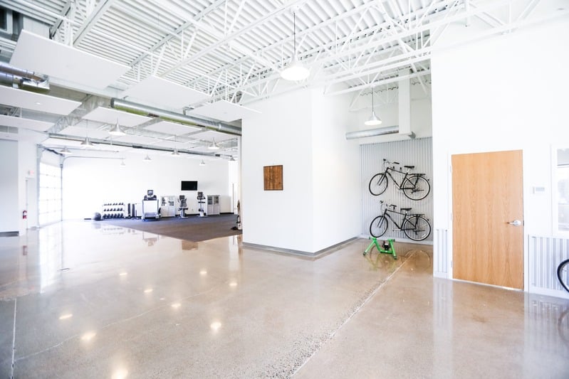 Bright, open rehabilitation and fitness facility with polished floors and bicycles mounted on the wall.
